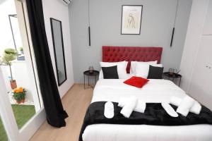a bedroom with a large white bed with a red headboard at Penthouse in the Heart of Athens in Athens