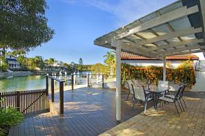 a patio with a table and chairs under a pergola at 44 Cooran Court in Noosa Heads