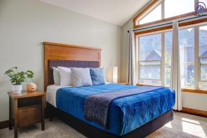 um quarto com uma cama e uma grande janela em Fire Mountain Two Bedroom Condo em Canmore