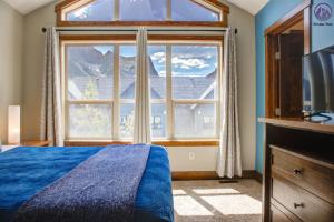 a bedroom with a bed and a large window at Fire Mountain Two Bedroom Condo in Canmore