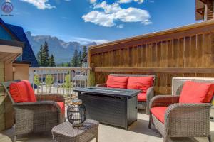 a patio with chairs and a piano on a fence at Fire Mountain Two Bedroom Condo in Canmore