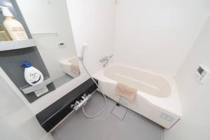 La salle de bains blanche est pourvue d'un lavabo et de toilettes. dans l'établissement Granduo 松濤, à Tokyo