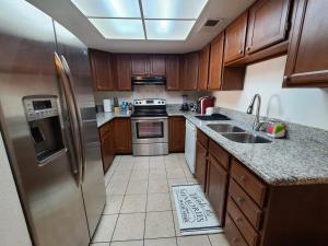 a kitchen with wooden cabinets and a stainless steel refrigerator at 2bed 1 bath condo near Nellis afb & the strip in Las Vegas
