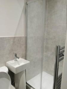 a bathroom with a shower and a sink and a toilet at Ensuite double-bed (G1) close to Burnley city centre in Burnley