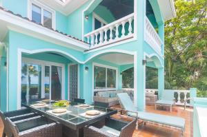 una casa azul con mesa y sillas en Coral Vista #5 Home, en Roatan
