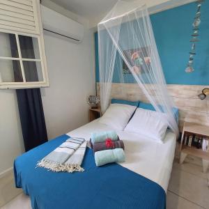 a bedroom with a blue and white bed with two pillows at Logisrev in Sainte-Anne