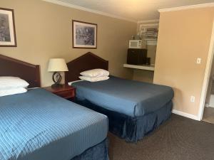 a hotel room with two beds and a lamp at Steelhead Inn in Erie