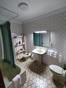 La salle de bains est pourvue d'un lavabo, de toilettes et d'une douche. dans l'établissement Acogedor piso en primera línea de mar- 8 huéspedes, à A Guarda