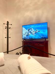 una sala de estar con TV de pantalla plana en una cómoda en Emerald Apartment, en Spáta