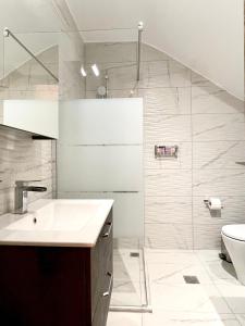 La salle de bains est pourvue d'un lavabo et de toilettes. dans l'établissement Emerald Apartment, à Spáta