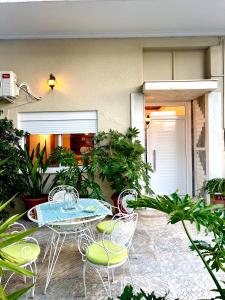une terrasse avec une table, des chaises et des plantes dans l'établissement Emerald Apartment, à Spáta