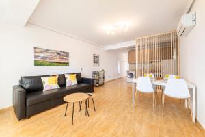 un salon avec un canapé noir et une table dans l'établissement Trendy Homes Chumberas Seaview, à Roquetas de Mar