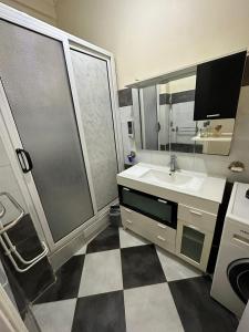 een badkamer met een douche, een wastafel en een spiegel bij Résidence Bejaia Legacy in Bejaïa