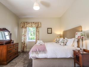 a bedroom with a bed and a dresser and a television at Old Distillery in Halkirk