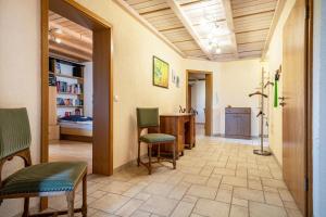- un couloir avec des chaises et un bureau dans la chambre dans l'établissement Urlaub auf dem Hirschhof Stehle, à Waldburg