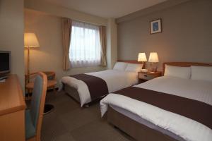 Postel nebo postele na pokoji v ubytování Toyooka Sky Hotel