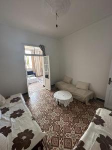 een woonkamer met 2 bedden en een bank bij Résidence Bejaia Legacy in Bejaïa