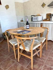 a wooden table with two chairs and a bottle of wine at Cuevas El Atochal Orígenes in Gor