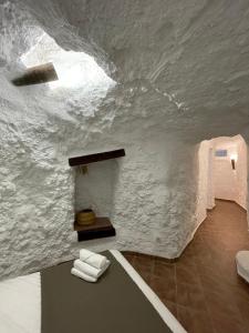 um quarto branco com toalhas numa mesa em Cuevas El Atochal Orígenes em Gor