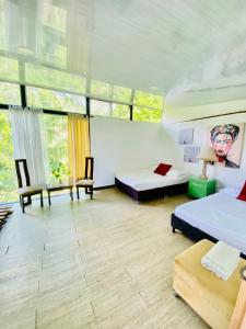 Pokój z 2 łóżkami, krzesłami i oknami w obiekcie Cabaña Tierra Verde eje Cafetero w mieście Manizales