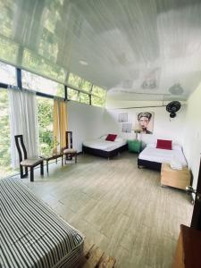 a bedroom with two beds and a large window at Cabaña Tierra Verde eje Cafetero in Manizales