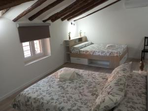 - une chambre avec 2 lits et une fenêtre dans l'établissement Apartamentos "El Balconico", à Arguedas