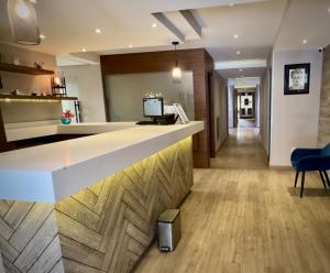 an office lobby with a reception counter and blue chairs at Hotel Monarca in Mexico City