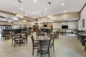 ein Restaurant mit Tischen und Stühlen und eine Bar in der Unterkunft Best Western Plus Texoma Hotel & Suites in Denison