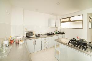 Una cocina con gabinetes blancos y encimera. en Tu Refugio Acogedor en el corazón de Medellín Hab Privada A, en Medellín 20 fotos más