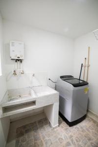 een witte badkamer met een wastafel en een vuilnisbak bij Experiencia Única Habitación Privada en Medellín A in Medellín