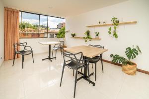 uma sala de jantar com uma mesa e cadeiras e uma janela em Experiencia Única Habitación Privada en Medellín A em Medellín