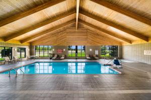 une grande piscine intérieure avec un grand plafond en bois dans l'établissement Best Western Derby Inn, à Eagle River