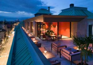 - un toit-terrasse avec des tables et des chaises dans un bâtiment dans l'établissement Radisson Collection Hotel, Santa Sofia Milan, à Milan