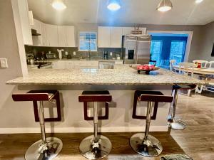 Casa La Vista a modern home in a natural setting في بيلا فيستا: مطبخ مع منضدة مع ثلاثة كراسي بار