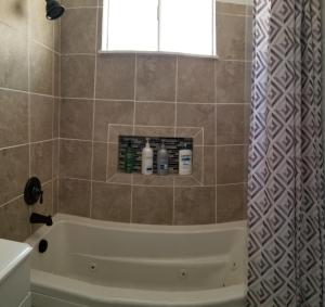 een badkamer met een bad en een douche met een raam bij Panoramic Lake View, Lake Isabella in Wofford Heights