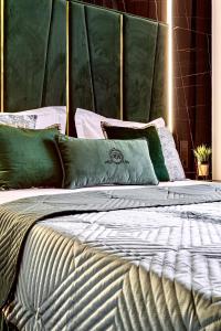 a large bed with green and white pillows on it at Central Family Boutique Apartments 3 in Lviv