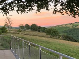 a view from the balcony of a house with a sunset at Tal-y-fan farm (5m luna tent) in Bridgend