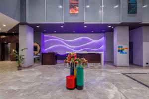 a lobby with purple walls and flowers on a table at Park Inn by Radisson Samsun in Samsun