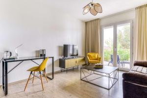 a living room with a desk and a yellow chair at Sure Hotel by Best Western Beziers Le Monestie in B&eacute;ziers