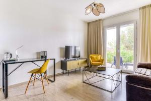 soggiorno con scrivania e sedia gialla di Sure Hotel by Best Western Beziers Le Monestie a Béziers