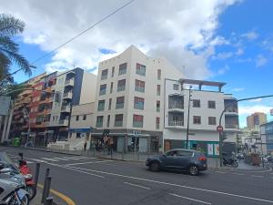 ein Auto, das vor einem Gebäude in einer Straße geparkt ist in der Unterkunft NG LA SALLE - Santa Cruz de Tenerife in Santa Cruz de Tenerife