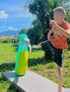 a young boy is standing next to a skateboard at Auto camp Radoman in Virpazar