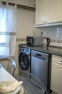 a kitchen with a dishwasher and a washing machine at Central Apartment in Belas, Lisbon in Belas