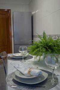 a table with plates and wine glasses on it at Central Apartment in Belas, Lisbon in Belas