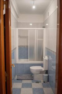 a bathroom with a toilet and a window at Central Apartment in Belas, Lisbon in Belas
