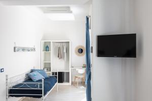 1 dormitorio con 1 cama y TV en la pared en B&B Sapore di Mare nel Blu, en Gaeta