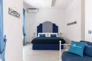 una camera d'albergo con due letti e un divano di B&B Sapore di Mare nel Blu a Gaeta