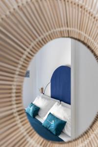 uno specchio che riflette un letto con testiera e cuscini blu di B&B Sapore di Mare nel Blu a Gaeta