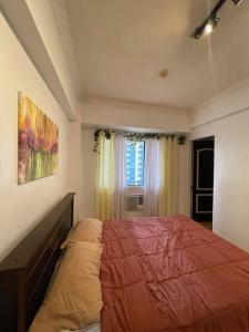 a bedroom with a bed and a window at Stylish and Cozy 3BR in the Heart of BGC in Manila