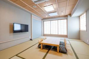 a conference room with a table and a tv at Ryokan Ginkaku Kyoto in Kyoto